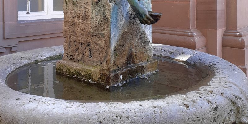 Wasserschöpfender Knabe