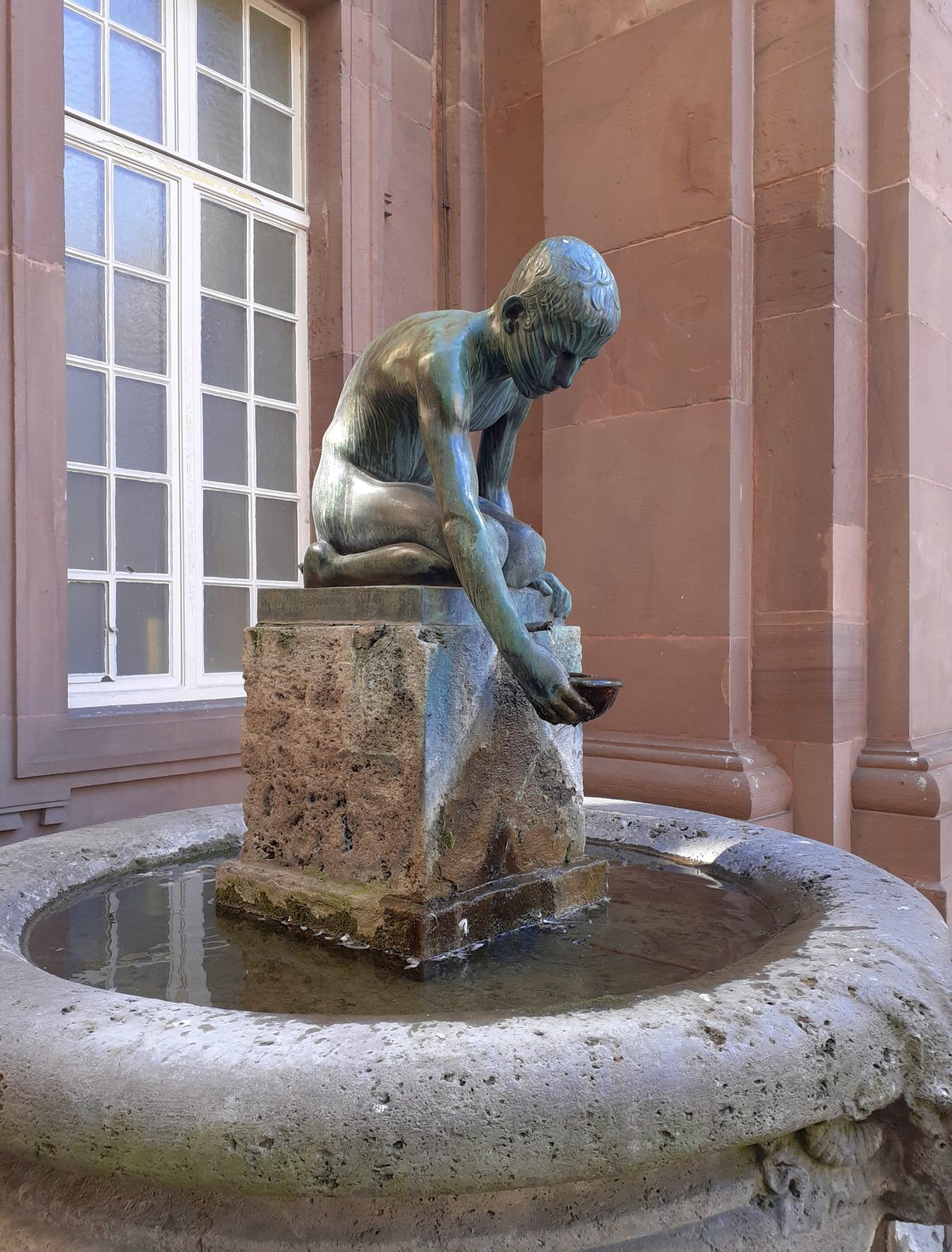 Wasserschöpfender Knabe